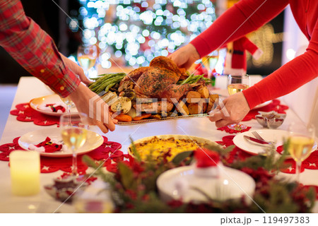 Family with kids having Christmas dinner at tree 119497383