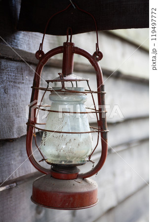 Antique rusty kerosene lantern on wooden wall. 119497772