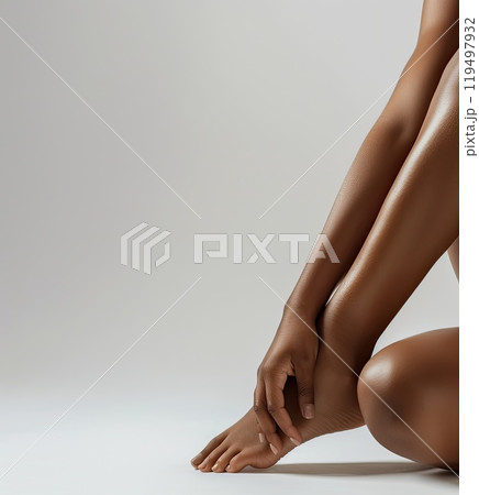 A woman sits on the floor with crossed legs, hands on knees 119497932