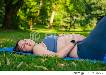 Female resting after practicing fitness exercises in park during sunny spring day 119498227