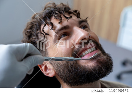 Unrecognizable dentist examining patient’s teeth using specialized dental tools Unrecognizable dentist examining patient’s teeth using specialized dental tools 119498471