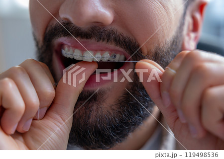 Male with using dental floss doing daily oral hygiene routine Male with using dental floss doing daily oral hygiene routine 119498536