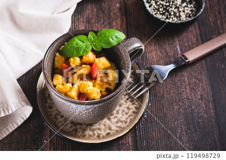 White bread pudding with egg, cheese and pepper in a cup on the table White bread pudding with egg, cheese and pepper in a cup on the table 119498729