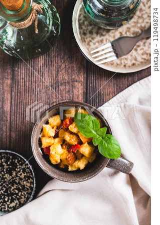 White bread pudding with egg, cheese and pepper in a cup on the table top and vertical view 119498734