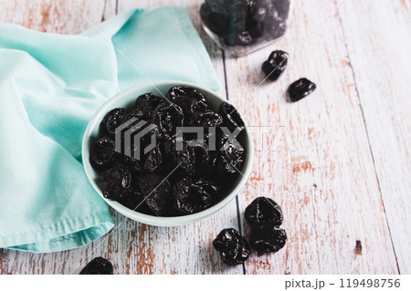Blue bowl with natural organic prunes on table 119498756