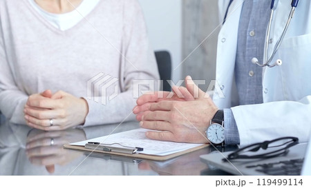 Doctor man and woman patient are discussing something and gesturing with their hands in medical office, close up. Medicine concept Doctor man and woman patient are discussing something and gesturing with their hands in medical office, close up. Medicine concept 119499114