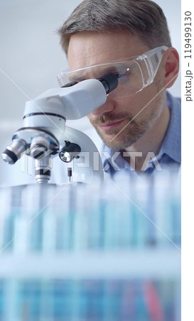 Man scientist with protective glasses and gloves is using micros 119499130