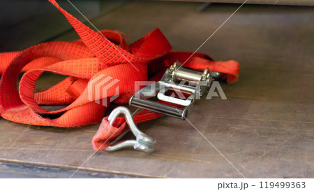 A red lashing strap thrown onto the floor of the truck body 119499363