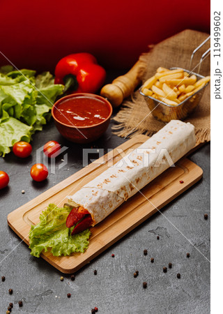 Grilled sausage wrap with fresh lettuce, a perfect quick snack or meal for on-the-go moments 119499602