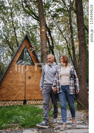 Romantic walk through nature near a cozy wooden cabin, capturing the charm of outdoor getaways 119499626