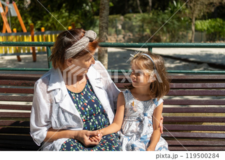 Grandmother and girl looking at each other while 119500284