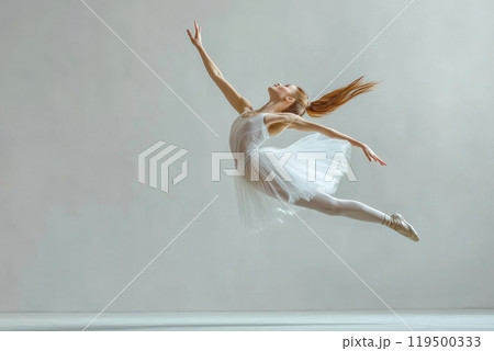 Ballerina is gracefully jumping mid air in a dance studio 119500333