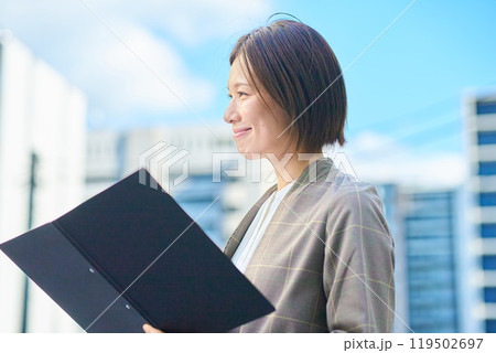 集合住宅の前に立つビジネスウーマン 119502697