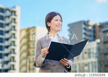 集合住宅の前に立つビジネスウーマン 集合住宅の前に立つビジネスウーマン 119502699