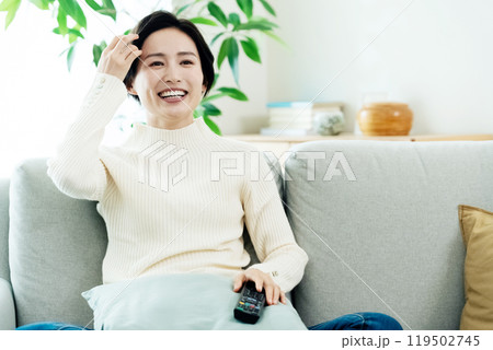 リモコンを操作する女性 119502745