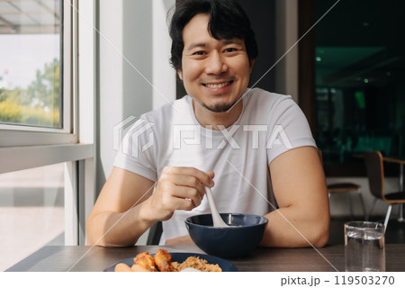 Happy man is having breakfast in the hotel dinning room. Happy man is having breakfast in the hotel dinning room. 119503270