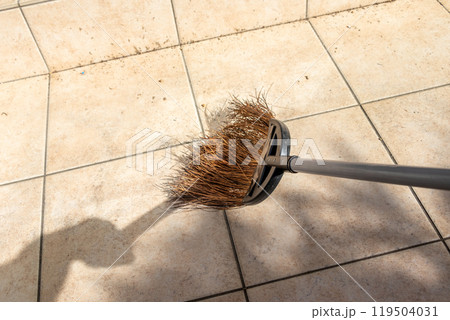 タイル張りのテラスをほうきで掃く タイル張りのテラスをほうきで掃く 119504031