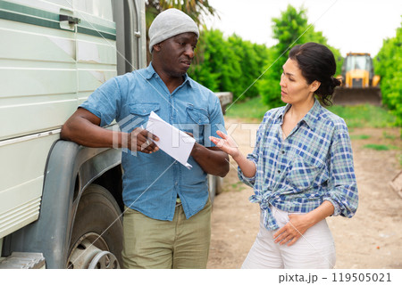 African farmer and asian woman discussing, standing at orchard African farmer and asian woman discussing, standing at orchard 119505021