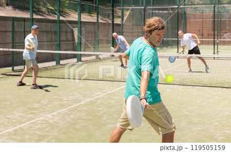 Adult men playing padel against two men Adult men playing padel against two men 119505159