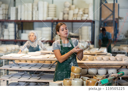 Woman ceramist working in pottery workshop 119505225