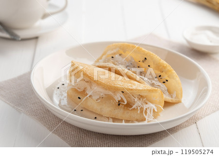 Khanom thang taek or Khanom Tang Thong, also known as poor man's pancake.Thai coconut pancake stuffed with shredded coconut and sugar sesame seed topping,a roadside snack in Thailand. 119505274