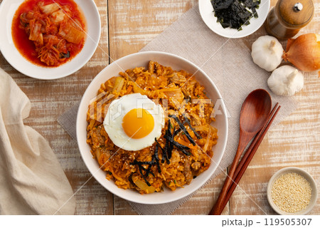 Kimchi fried rice with pork topped with fried egg sesame seed and Crispy Seaweed in white plate.Korean food.Top view. 119505307