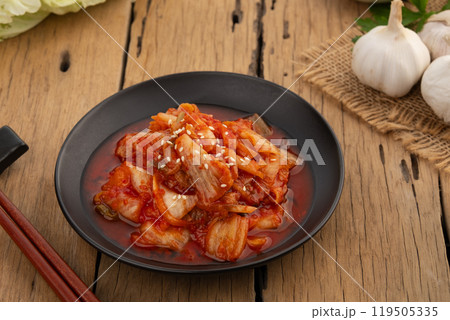 Napa cabbage kimchi topped with white sesame seed in black plate,Korean fermented side dish food. 119505335