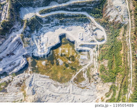 Stone quarry in the forest. Flying over the summer mixed forest during sunset. The surroundings of Yekaterinburg. Ural, Russia, Aerial View 119505489