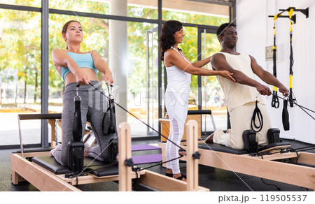 Positive woman and African American man training with female instructor Positive woman and African American man training with female instructor 119505537