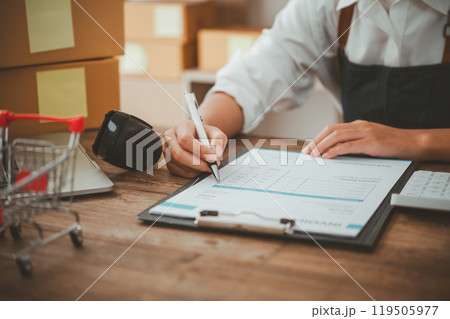 Small SME business owners work with laptop computers at work. and have products ready to ship. customers have ordered of online retailers,Ecommerce 119505977