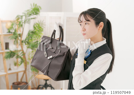 中古のバッグの査定をする女性スタッフ 119507049