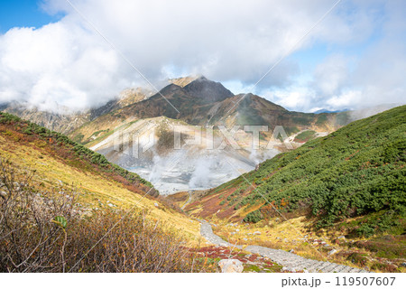 Murodo, Tateyama Kurobe Alpine Route, Japan, A serene mountain landscape with rolling hills and smoke from volcano Murodo, Tateyama Kurobe Alpine Route, Japan, A serene mountain landscape with rolling hills and smoke from volcano 119507607