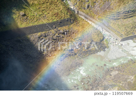 Kurobe Dam, Tateyama, Toyama, Chubu, Japan A vibrant rainbow arcs over a rocky terrain and flowing water 119507669