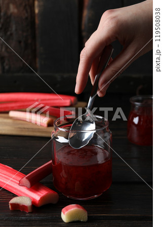 Rhubarb jelly in a jar with fresh rhubarb stems on a dark background Rhubarb jelly in a jar with fresh rhubarb stems on a dark background 119508038