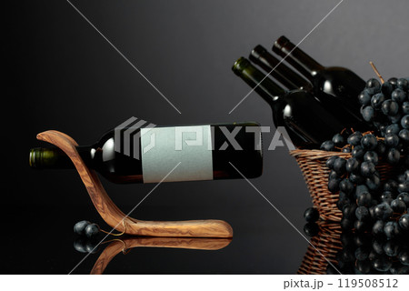 Red wine and blue grapes on a black reflective background. Red wine and blue grapes on a black reflective background. 119508512