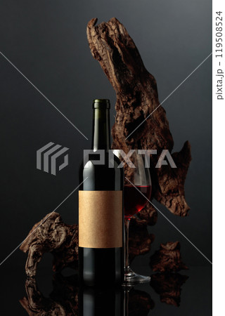 Red wine and old weathered snag on a black background. Red wine and old weathered snag on a black background. 119508524