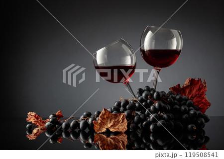 Glasses of red wine and blue grapes. Glasses of red wine and blue grapes. 119508541