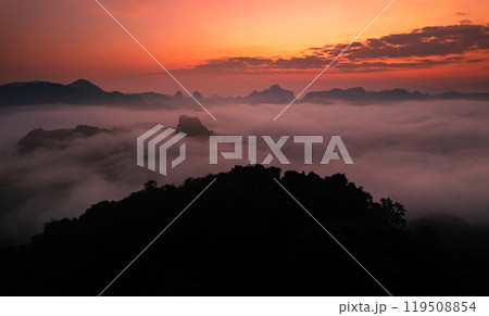 Aerial View of Morning fog and mountains as the sun rises from above 119508854