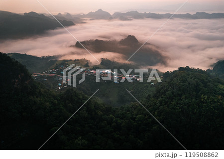 Aerial view of Morning fog and mountains with a rural village and sunrise from above 119508862