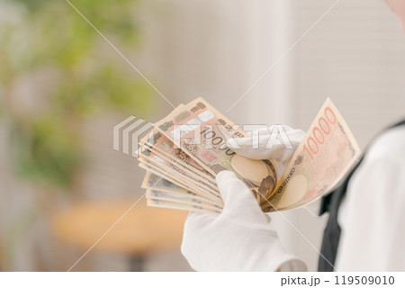 お金を数える白い手袋の女性の手元 お金を数える白い手袋の女性の手元 119509010