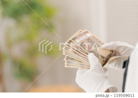 お金を数える白い手袋の女性の手元 119509011