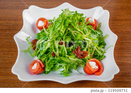 Fresh salad with arugula, salmon, cream cheese and sun-dried tomatoes on wooden table Fresh salad with arugula, salmon, cream cheese and sun-dried tomatoes on wooden table 119509731