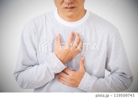 胸を押さえて胸痛に苦しむミドル男性 119509743
