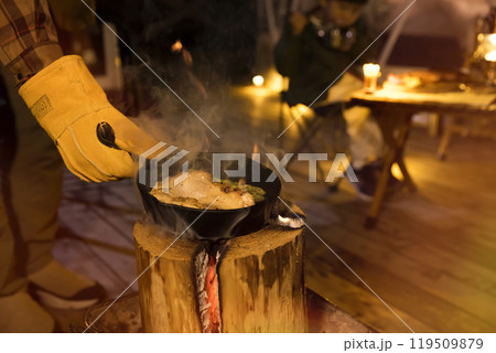 スウェーデントーチでアヒージョをする男性手元 119509879