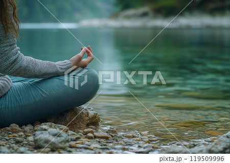 A tranquil moment of meditation by a serene lakeside, connecting with nature's beauty at dawn 119509996