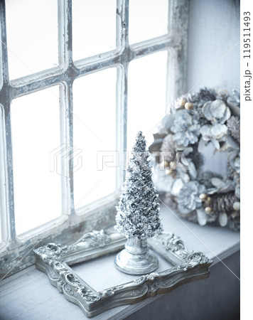 窓辺に飾られたクリスマスツリーとクリスマスリース 119511493