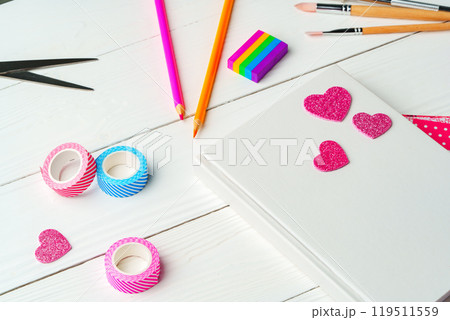 Crafting a colorful workspace with decorations, stationery, and artistic tools on a clean wooden surface 119511559