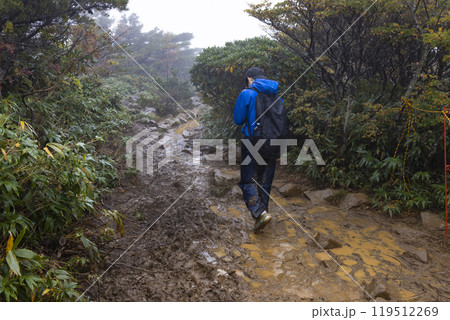 小雨の中、登山をする男の子 119512269