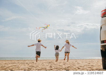 Asian family is flying a kite while running on the beach. Happy parents mother and father with their child playing with kite, The car is parked nearby, and the family is enjoying their time together Asian family is flying a kite while running on the beach. Happy parents mother and father with their child playing with kite, The car is parked nearby, and the family is enjoying their time together 119514607