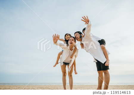 Joyful family on vacation at the beach. Parents with children laughing playing and enjoying the sun. Summer holidays depict happiness fun and freedom. Travel and family enjoyment Joyful family on vacation at the beach. Parents with children laughing playing and enjoying the sun. Summer holidays depict happiness fun and freedom. Travel and family enjoyment 119514613